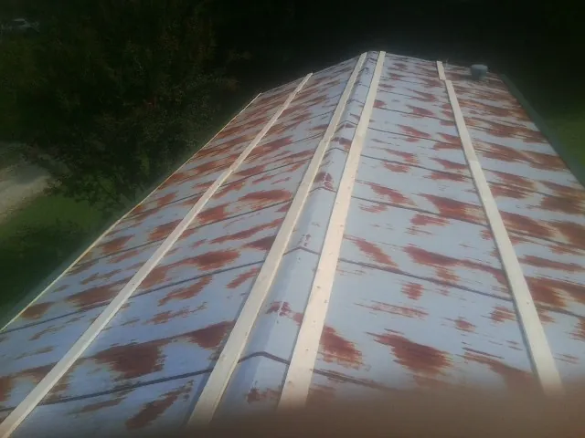 Rusted metal roof panels with new wood purlins before replacement — Storm Damage Roof Repair in Mc Graw by Roofing Brothers