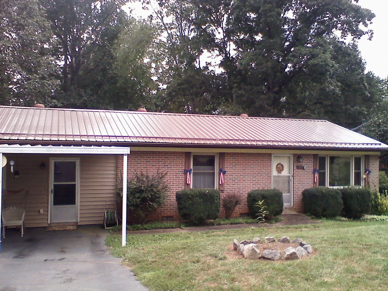 Bronze metal roof and carport on a brick ranch home — Roof Repair work by our crew in Mc Graw