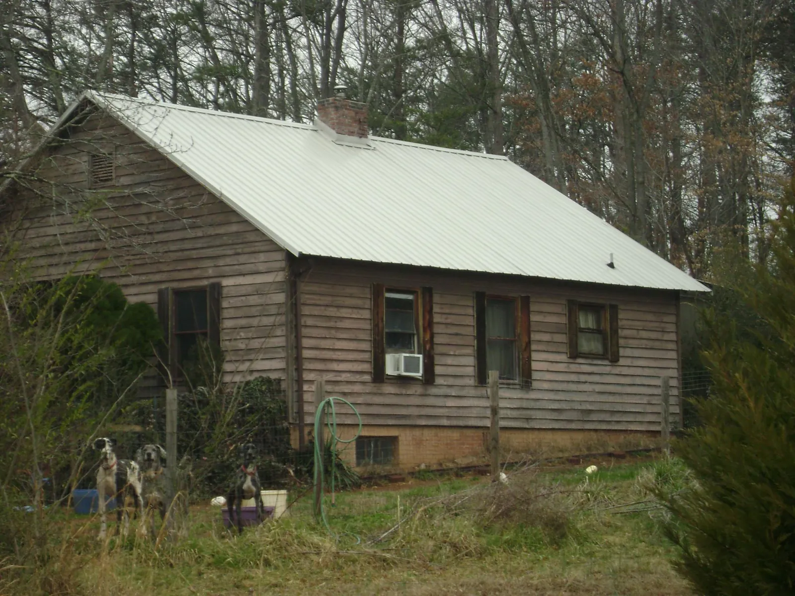 White metal roof on an old wood sided farmhouse, from a Metal Roof Installation job in Mc Graw